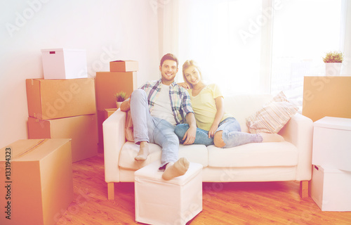 happy couple with big cardboard boxes at new home © Syda Productions