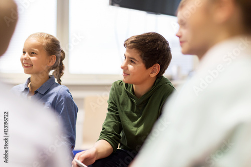 group of happy kids or friends learning at school