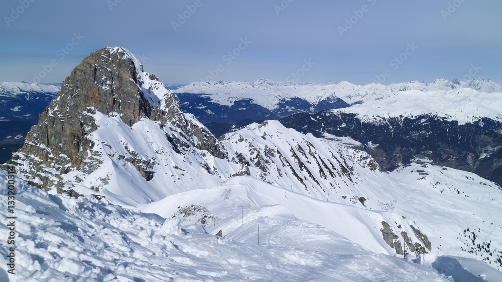 Alpine snowy peaks panorama, skiing piste on an edge of a rock, Meribel resort, 3 Valleys, Alps, France
