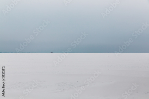 The gloomy winter sky over the snowy field.