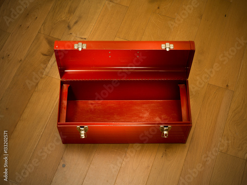 Empty red tool box on wooden floor