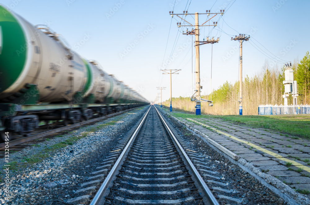 Train with oil tanks moving. Transportation of fuel on the railroad. Motion blur.