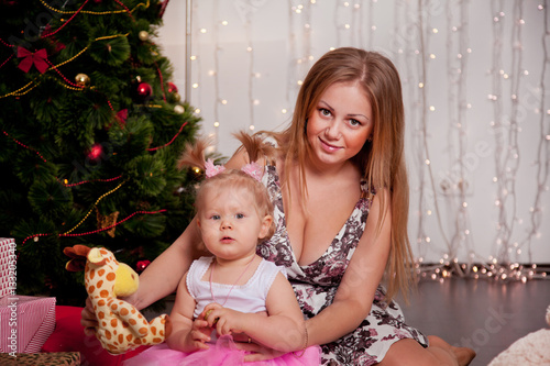 beautiful mother and daughter in front of a Christmas tree