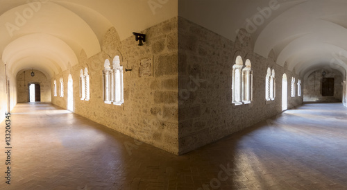 Gallerie in pietra del chiostro di un convento tra giochi di luce photo