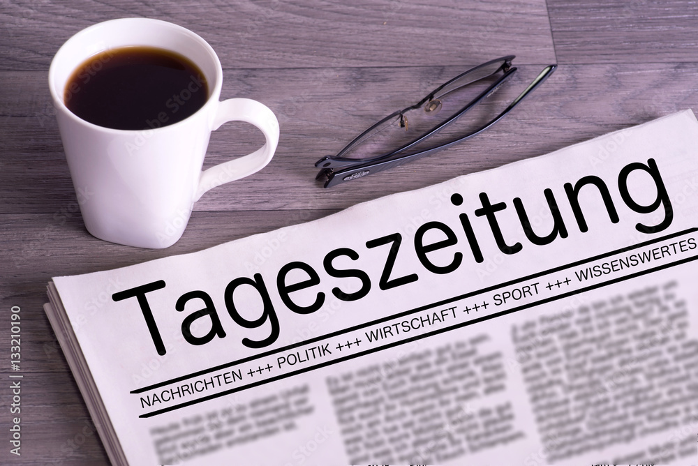 Eine Zeitung, Lesebrille und eine Tasse Kaffee Eine Zeitung, Lesebrille und eine Tasse Kaffee