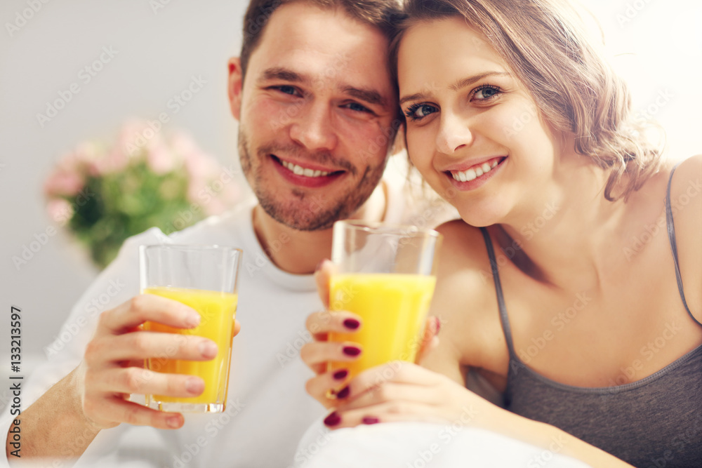 Young couple eating breakfast in bed Young couple eating breakfast in bed