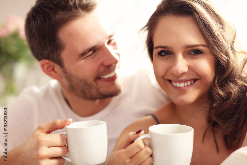 Young couple drinking coffee in bed Young couple drinking coffee in bed