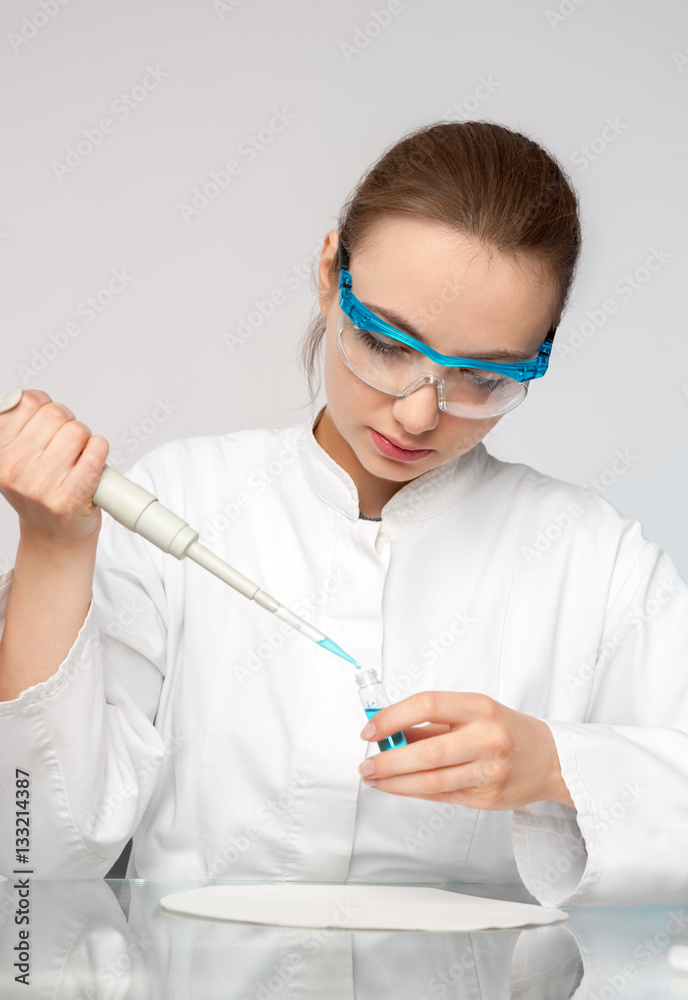 Young female tech or scientist loads sample Young female tech or scientist loads sample