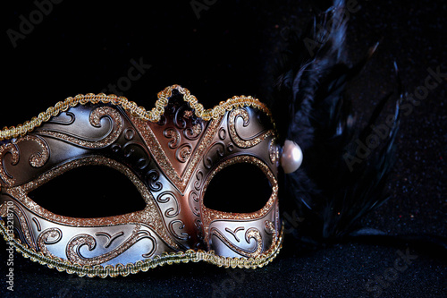 black venetian mask on glitter background