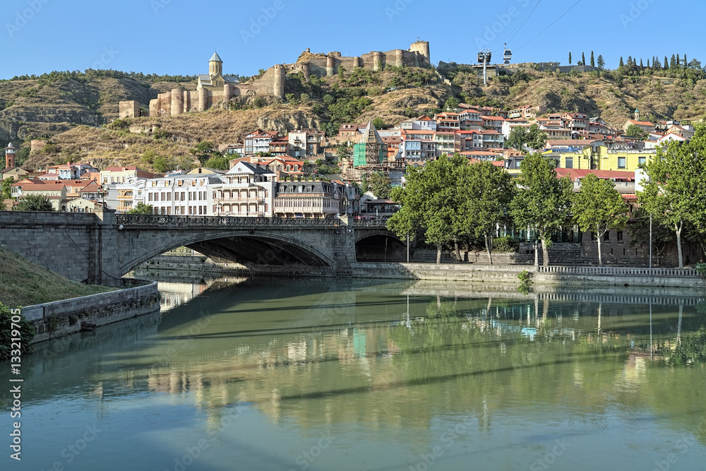 View of Narikala Fortress from the shore of Kura River near the Metekhi Bridge in Tbilisi, Georgia