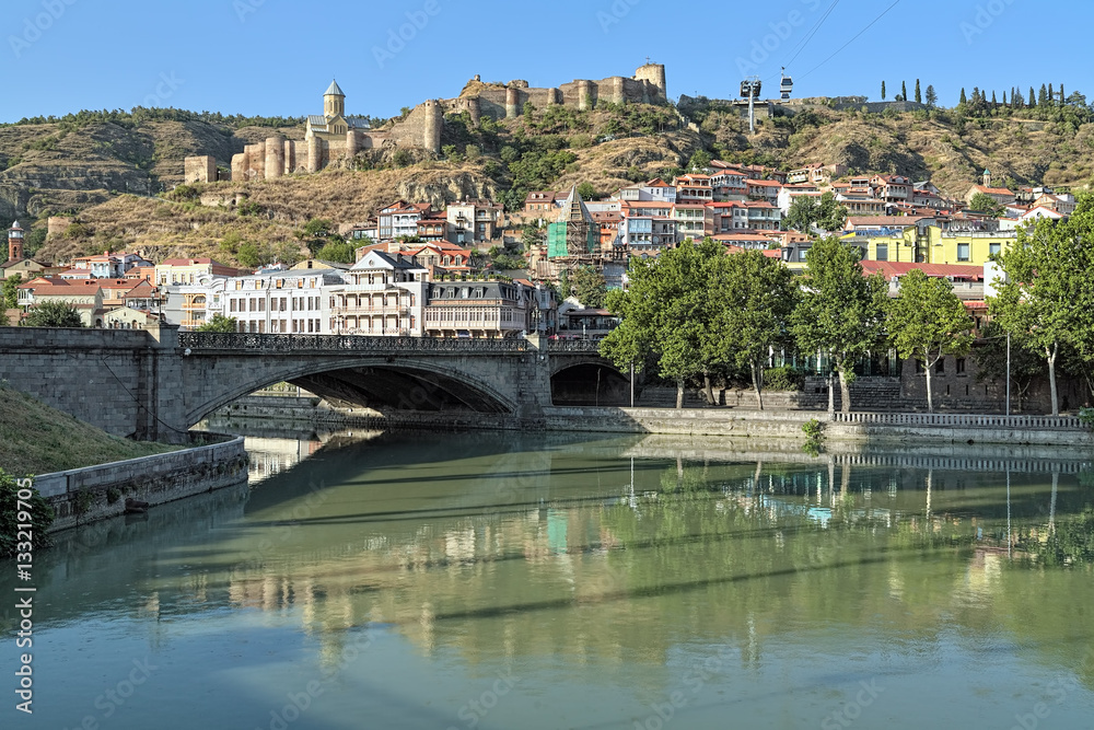Fototapeta premium View of Narikala Fortress from the shore of Kura River near the Metekhi Bridge in Tbilisi, Georgia