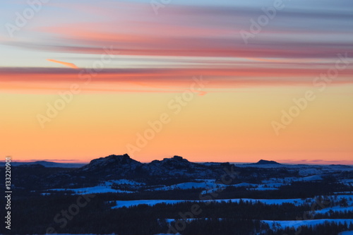 Pre-dawn sunrise over a snow covered Vedauwoo, Wyoming.  The 'turtle rock' rock formations are visible in the lower portion of the frame.   photo