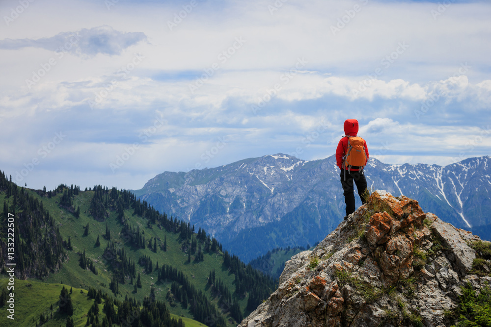 successful woman backpacker hiking on mountain peak cliff successful woman backpacker hiking on mountain peak cliff