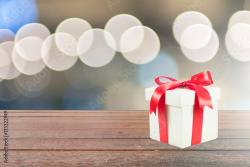 Gift box on wood texture with circle light bokeh background