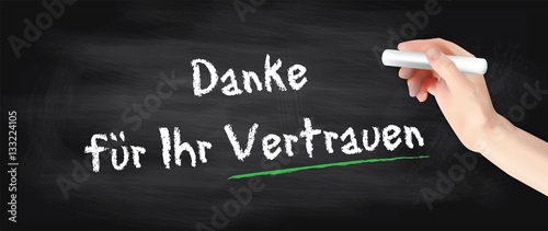 Hand schreibt auf Kreidetafel - Danke für Ihr Vertrauen