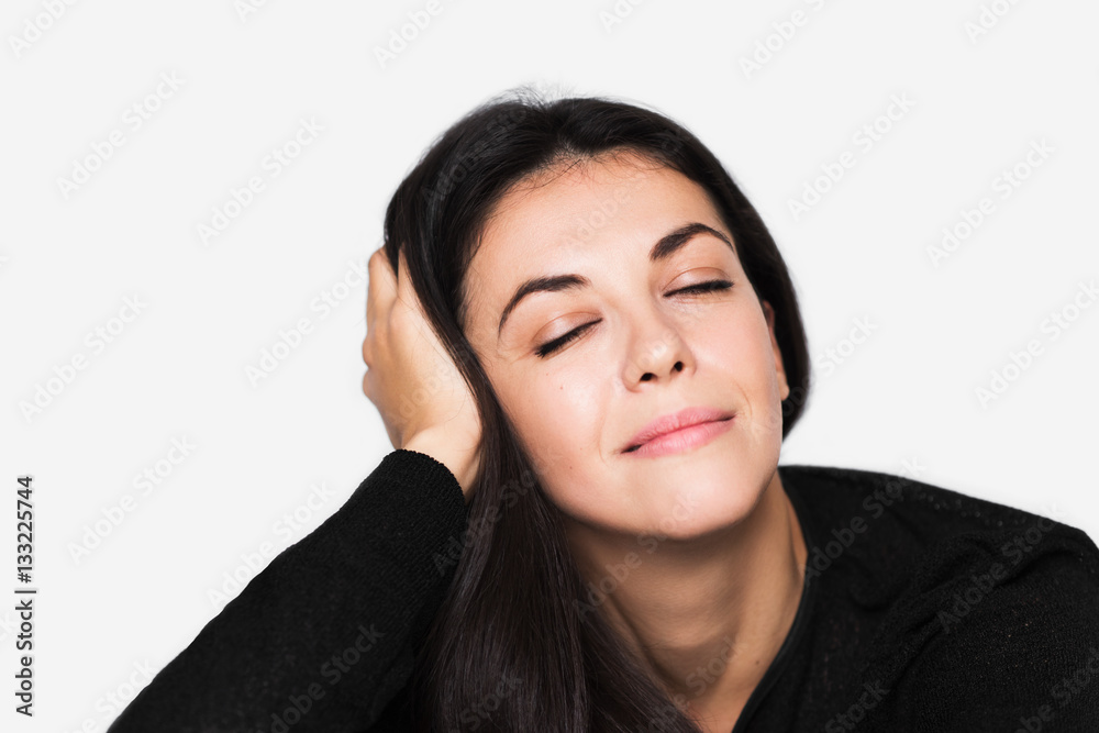Close up portrait of brunette cute dreamy woman with hand on hair. Young happy pretty woman with closed eyes wearing black sweater on light grey background. Pensive and dreaming mood. Close up portrait of brunette cute dreamy woman with hand on hair. Young happy pretty woman with closed eyes wearing black sweater on light grey background. Pensive and dreaming mood.