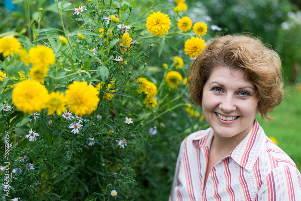 Smiling woman near yellow flowers in nature Smiling woman near yellow flowers in nature