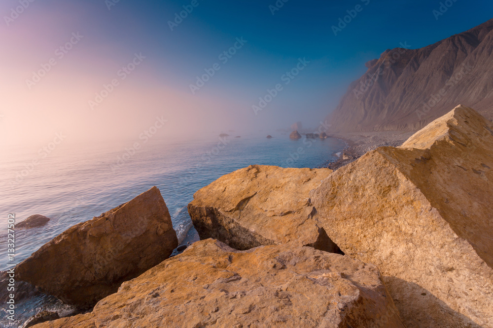 Seascape with coastline at sunrise. Coastal foggy morning landscape. Crimea.