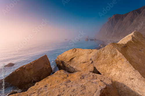 Seascape with coastline at sunrise. Coastal foggy morning landscape. Crimea.