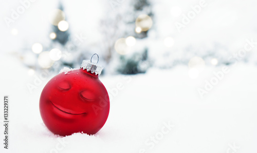 Weihnachtskugel mit Gesicht im Schnee photo