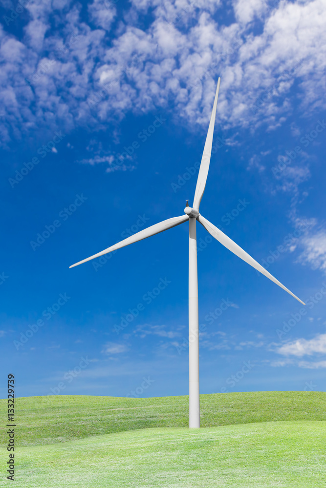 Fototapeta premium Wind turbines on grass field and blue sky