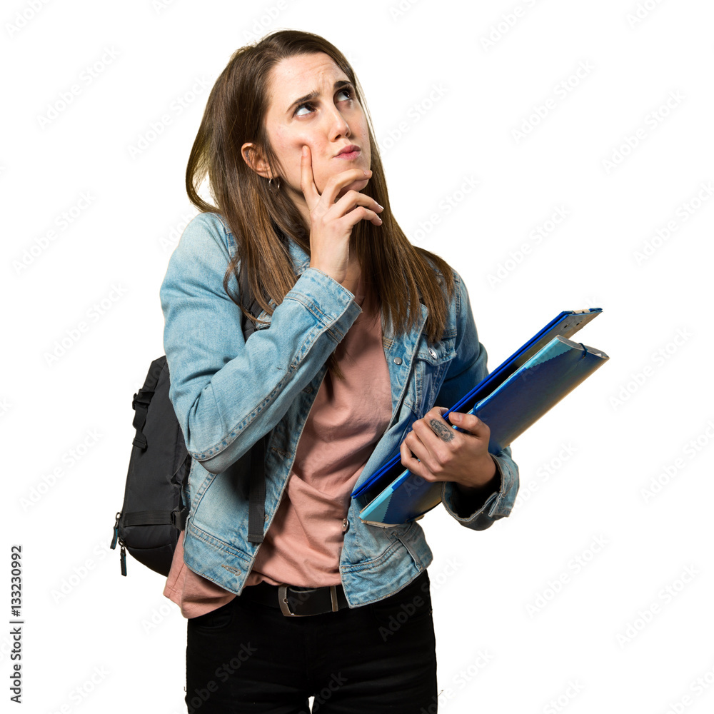 Teen student girl holding books and thinking Teen student girl holding books and thinking