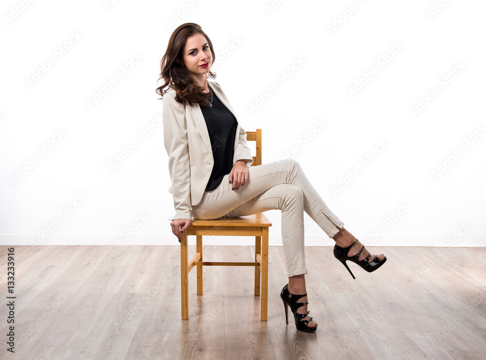 Beautiful brunette girl sitting on wooden chair Beautiful brunette girl sitting on wooden chair