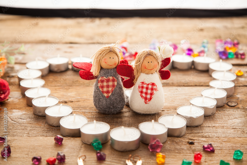 Valentine's day angels in made of candles heart with letters signed by colorful stones. Word Love signed with letters and toy couples.