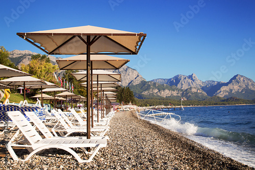 Fototapeta Naklejka Na Ścianę i Meble -  Sunshades and chaise lounges on beach. Summer seascape.