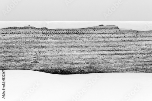 Old brick wall and snow in black and white.