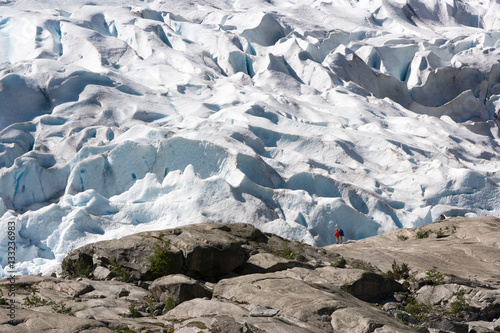 woman looks at Nigardsbreen glacier at Jostedal Nasjonal (National) Park, Norwa photo