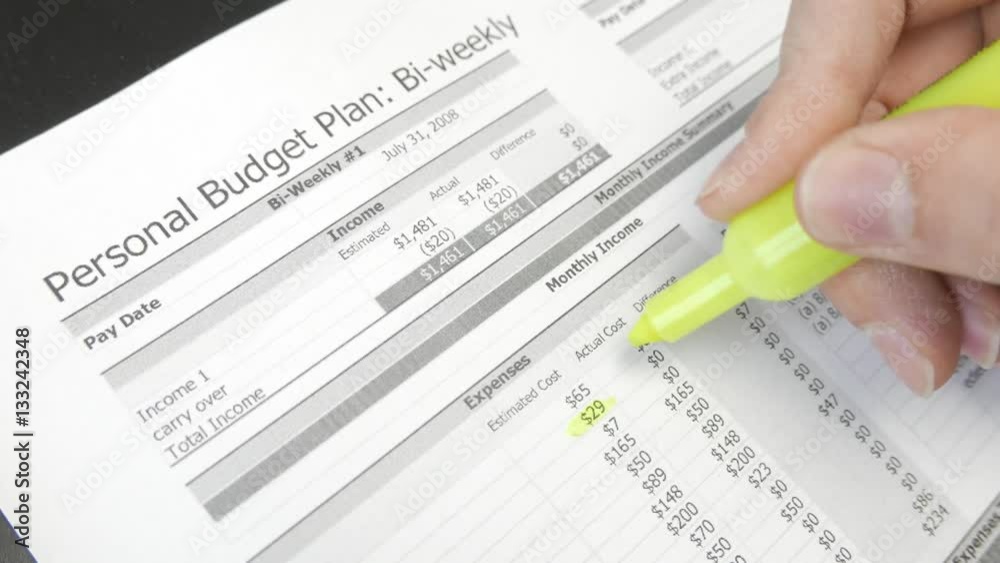 Using a highlighter marker on a personal budget sheet showing the expenses of the family. Using a highlighter marker on a personal budget sheet showing the expenses of the family.