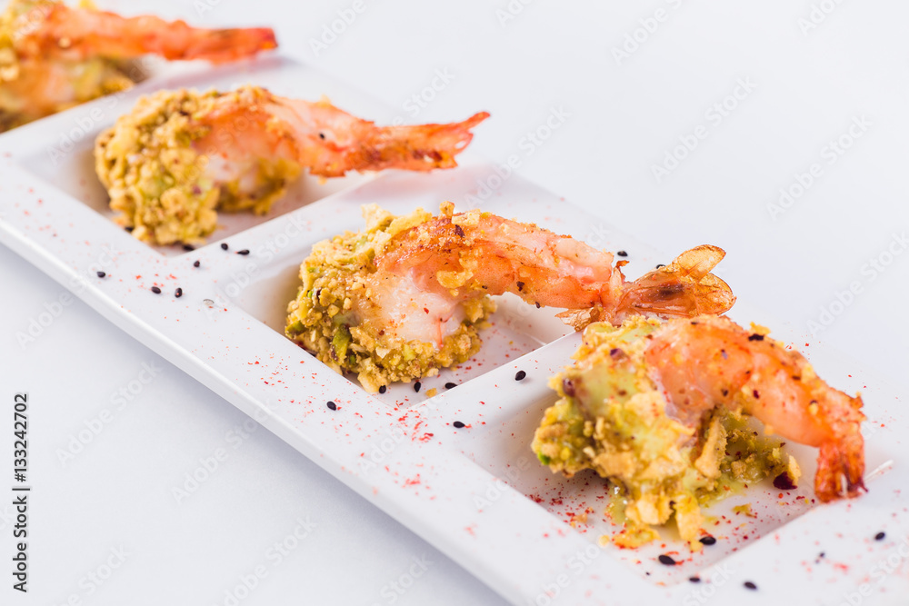 King prawns in batter in a white plate on a light background (close up )