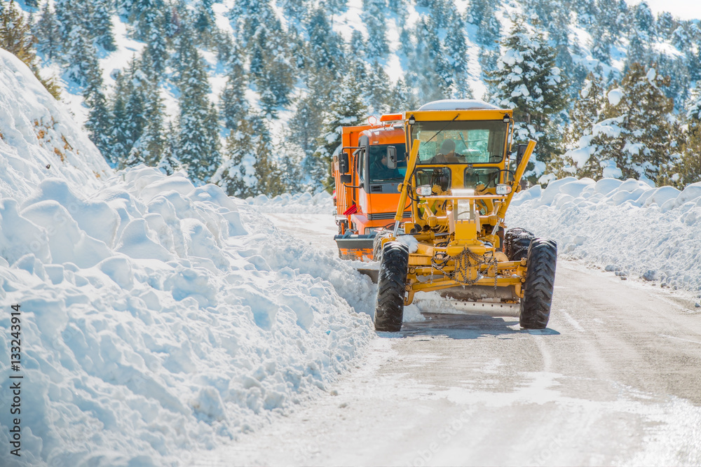 The bulldozer cleans snow on road The bulldozer cleans snow on road