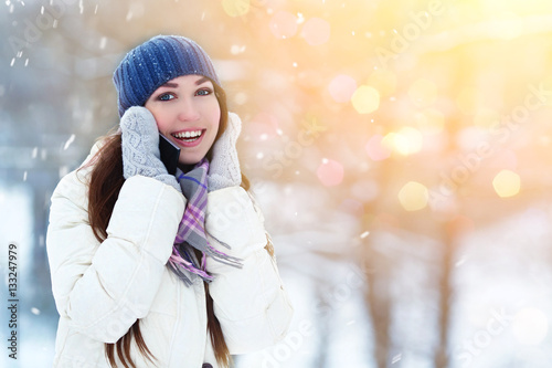 Portrait of smiling young woman talking mobile phone in winter park