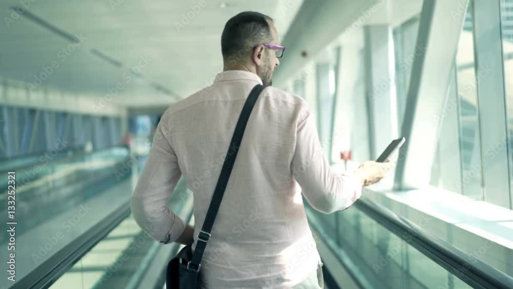 Young man riding on escalator stairs and checking his phone
Young man riding on escalator stairs and checking his phone