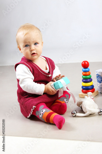Shot of an adorable baby girl in red clothes playing with some wooden toys. 