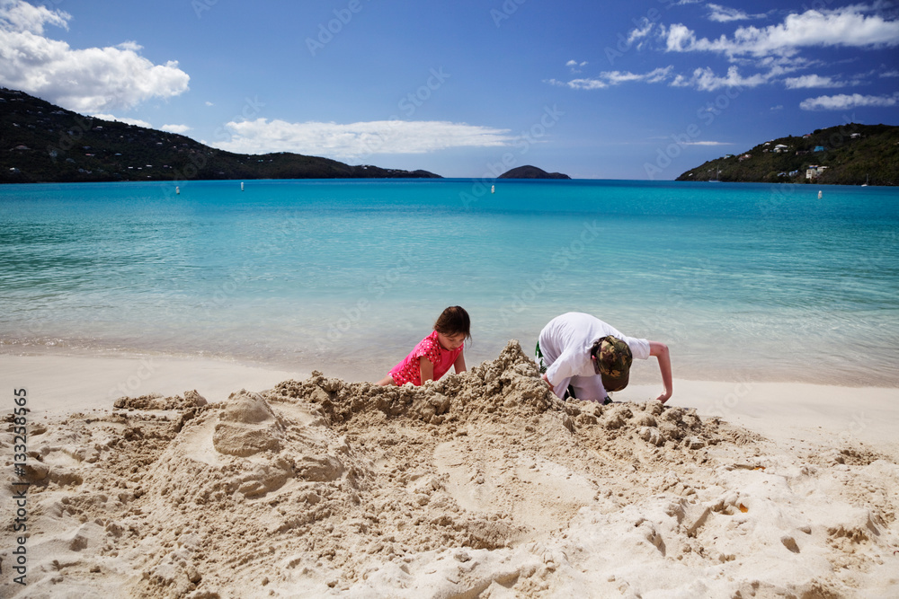 Brother and sister build sandcastles on the beach in Magens Bay, St. Thomas Brother and sister build sandcastles on the beach in Magens Bay, St. Thomas