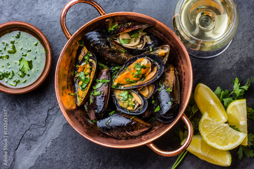Mussels in copper bowl, lemon, herbs sauce and white wine. Mussels in copper bowl, lemon, herbs sauce and white wine.