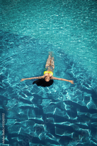 Sexy tanned woman in pool water bikini model