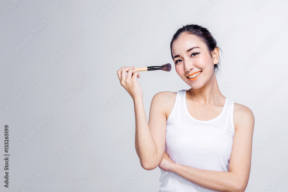 Asian woman holding brushes - beauty makeup concept Asian woman holding brushes - beauty makeup concept