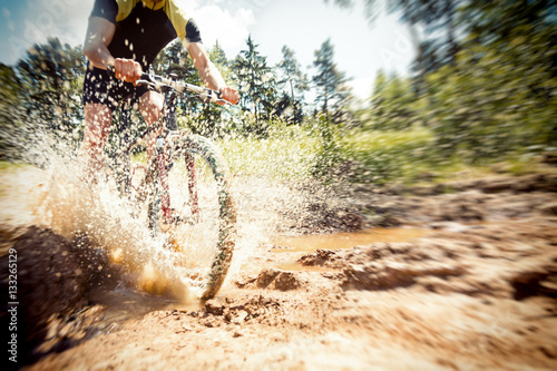 Mountain Biker Riding Through A Dirty Puddle