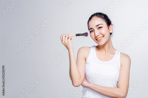 Asian woman holding brushes - beauty makeup concept