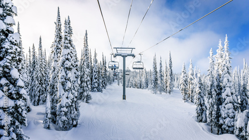Riding the Chair Lift in a Winter Landscape on the Ski Hills near Sun Peaks village in the Shuswap Highlands of central British Columbia, Canada