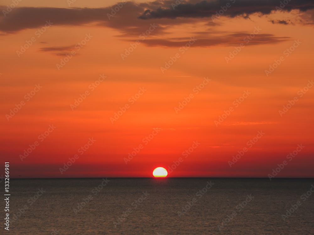 Fiery sunrise at Italian beach. Summer season. Emilia Romagna region. Adriatic sea. Italy