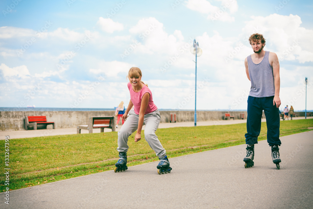 Fototapeta premium Two people race together riding rollerblades.