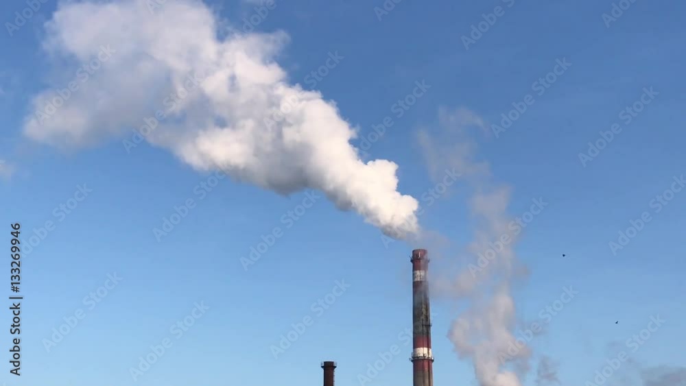 Factory fuming pipe on the background of clear blue sky, day Factory fuming pipe on the background of clear blue sky, day