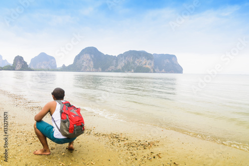 Traveler backpack looking mountain and sea view in evening.Or traveler man with sea view