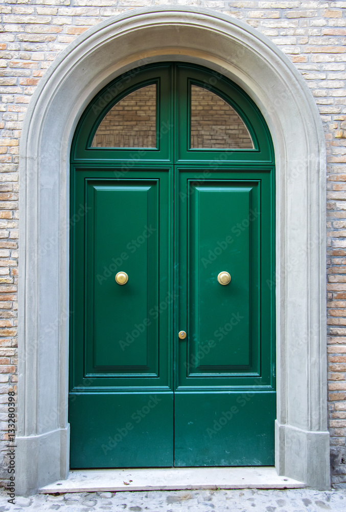 Green exterior door entrance with briks wall background.