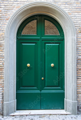 Green exterior door entrance with briks wall background. © PerseoMedia